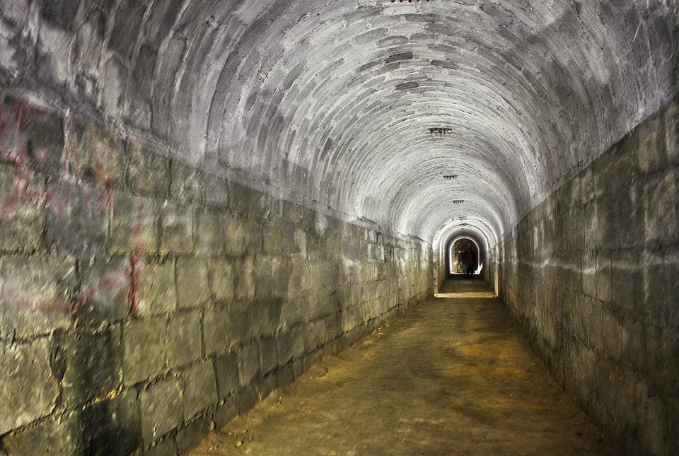 Centrální chodba krytu je kolmá na tři chodby vstupní a spojuje všechna zajímavá místa uvnitř. Na stropě jsou dobře patrné izolátory po elektrickém vedení. Centrální chodba krytu je kolmá na tři chodby vstupní a spojuje všechna zajímavá místa uvnitř. Na stropě jsou dobře patrné izolátory po elektrickém vedení.