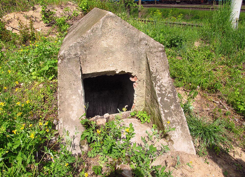 Hlavní a jediný vstup do krytu je nenápadný a vypadá jako malý betonový model nějaké jiné stavby. Hlavní a jediný vstup do krytu je nenápadný a vypadá jako malý betonový model nějaké jiné stavby.
