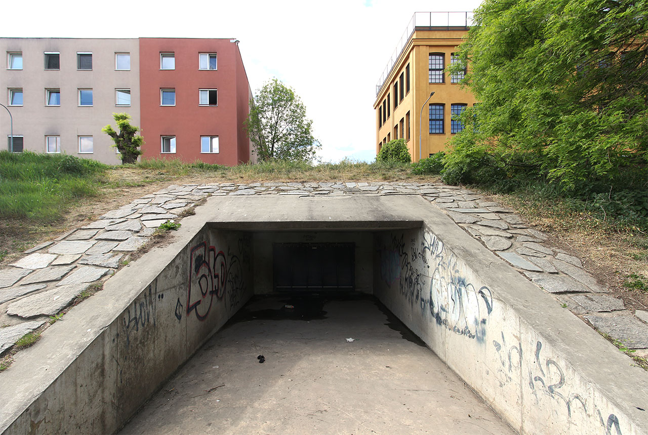 Betonová tlama neomylně zve ke vstupu každého, komu v žilách koluje romantická krev. Stačí nadzvednout docela lehkou plastovou klapku (nedělaly se dřív tyhle klapky z litiny?). Betonová tlama neomylně zve ke vstupu každého, komu v žilách koluje romantická krev. Stačí nadzvednout docela lehkou plastovou klapku (nedělaly se dřív tyhle klapky z litiny?).