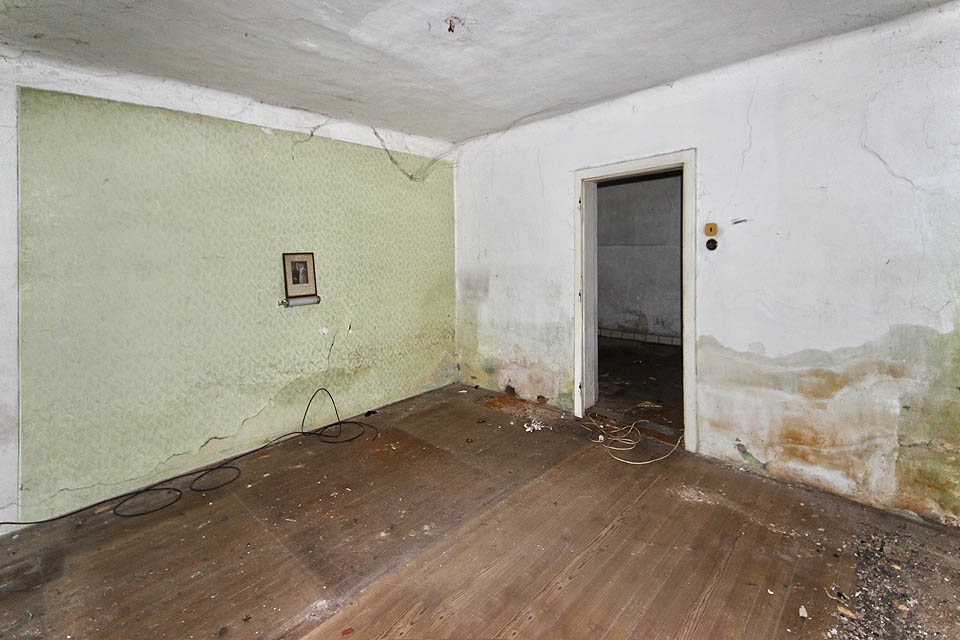 Obývací pokoj a ložnice současně odhaluje bídu zdejšího bydlení. Popraskané stěny a vlhká omítka nejsou ničím, po čem by kdokoliv toužil. Místo opravy však nyní dům čeká demolice. Obývací pokoj a ložnice současně odhaluje bídu zdejšího bydlení. Popraskané stěny a vlhká omítka nejsou ničím, po čem by kdokoliv toužil. Místo opravy však nyní dům čeká demolice.