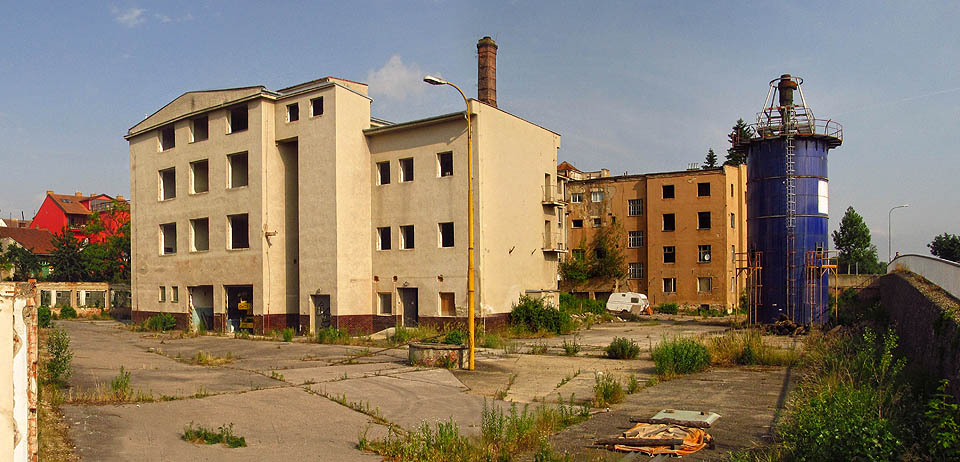 Pohled na západní polovinu areálu přeťatého prodloužením Střední ulice (na rampě vpravo) v roce 2014. Poslední stroje se dotočily před 11 roky, areál ale stále hlídá ostraha s krvelačným psem. Pohled na západní polovinu areálu přeťatého prodloužením Střední ulice (na rampě vpravo) v roce 2014. Poslední stroje se dotočily před 11 roky, areál ale stále hlídá ostraha s krvelačným psem.