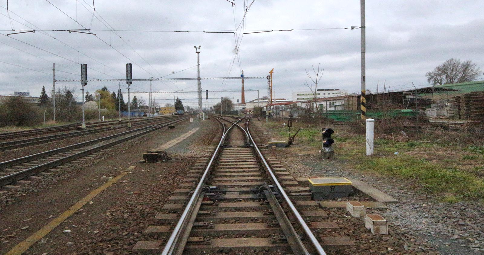 Pohled ze severního (Heršpického) zhlaví stanice Modřice směrem k cihleně. Z výhybky č. 17 (pod fotografem) je vidět výhybku č. 16 a vpravo od ní výhybku č. 14, ze které odbočuje a do vrat vchází kolej vlečky společnosti Firesta. Tudy vjížděly do areálu překladiště nákladní vlaky, aby se pak úvraťově vrátily k severu, k rampě úzkokolejky (je vidět na fotce vpravo). Pohled ze severního (Heršpického) zhlaví stanice Modřice směrem k cihleně. Z výhybky č. 17 (pod fotografem) je vidět výhybku č. 16 a vpravo od ní výhybku č. 14, ze které odbočuje a do vrat vchází kolej vlečky společnosti Firesta. Tudy vjížděly do areálu překladiště nákladní vlaky, aby se pak úvraťově vrátily k severu, k rampě úzkokolejky (je vidět na fotce vpravo).