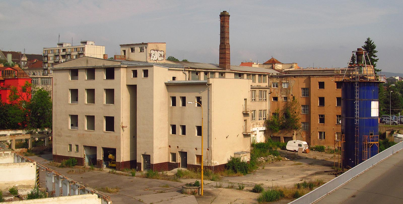 V roce 2014 ještě stály mohutné budovy nábytkářské továrny Tusculum. Východní dvě koleje úzkokolejky vedou před otvory po vratech (v jednom otvoru stojí jeřáb z ČKD) a končí pod zdí se zábradlím v pravém dolním rohu snímku. Rozpoznat je lze zejména podle plevele, který je obrůstá. Západní dvě koleje se skrývají za budovou na snímku vlevo. V roce 2014 ještě stály mohutné budovy nábytkářské továrny Tusculum. Východní dvě koleje úzkokolejky vedou před otvory po vratech (v jednom otvoru stojí jeřáb z ČKD) a končí pod zdí se zábradlím v pravém dolním rohu snímku. Rozpoznat je lze zejména podle plevele, který je obrůstá. Západní dvě koleje se skrývají za budovou na snímku vlevo.