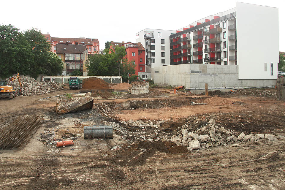 Celkový pohled na staveniště na místě někdejší továrny Tusculum ze Střední ulice. Východní koleje jsou dobře rozpoznatelné v levé dolní části snímku (jižnější již částečně vytrhaná, severnější prochází pod odloženou radlicí buldozeru). Pod koly zeleného nákladnícho auta začínají západní koleje, které vedou doprava k betonové zdi v zadním traktu nového domu. Celkový pohled na staveniště na místě někdejší továrny Tusculum ze Střední ulice. Východní koleje jsou dobře rozpoznatelné v levé dolní části snímku (jižnější již částečně vytrhaná, severnější prochází pod odloženou radlicí buldozeru). Pod koly zeleného nákladnícho auta začínají západní koleje, které vedou doprava k betonové zdi v zadním traktu nového domu.