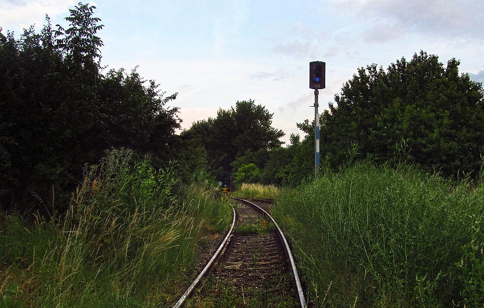 Za seřaďvoacím návěstidlem je dobře vidět brána areálu sila i odvratná kolej. Za seřaďvoacím návěstidlem je dobře vidět brána areálu sila i odvratná kolej.