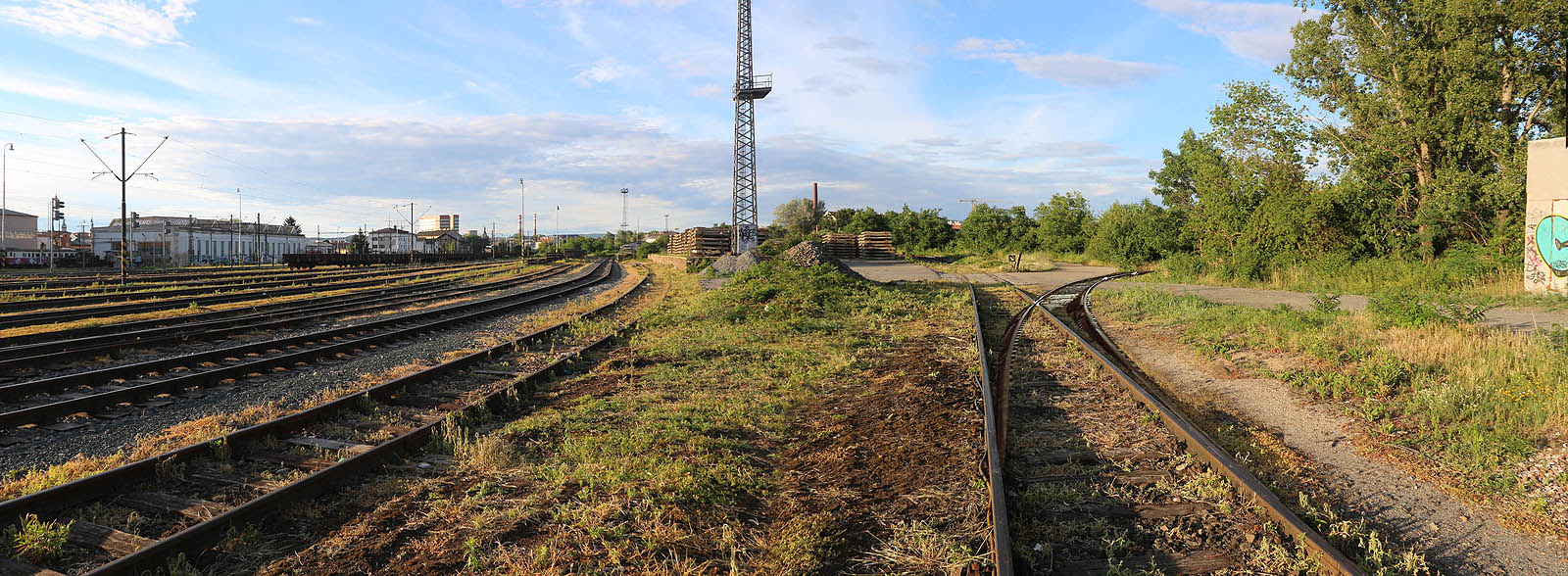 Tak nějak by vypadalo totéž místo, kdyby nebyla vlečka do komárovských skladů vytrhána a zrušena. Kolej se ostrým obloukem o poloměru zhruba 120 m odklání od nádraží a míří směrem k městu. Tak nějak by vypadalo totéž místo, kdyby nebyla vlečka do komárovských skladů vytrhána a zrušena. Kolej se ostrým obloukem o poloměru zhruba 120 m odklání od nádraží a míří směrem k městu.