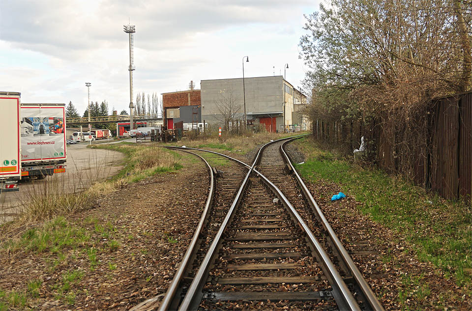 Ústřední bod vlečky. Doleva odbočuje kolej, která se původně větvila na nejméně šest dalších kusých kolejí, vpravo podél hranice areálu kolej k malému (dříve trojkolejnému) předávacímu kolejišti vlečky. Ústřední bod vlečky. Doleva odbočuje kolej, která se původně větvila na nejméně šest dalších kusých kolejí, vpravo podél hranice areálu kolej k malému (dříve trojkolejnému) předávacímu kolejišti vlečky.
