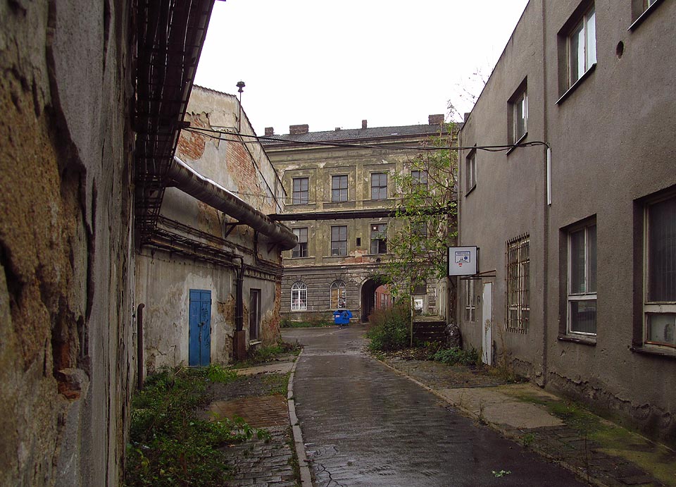 Původní cesta procházející branou paláce se stáčí k severu a končí mezi výrobními halami. Původní cesta procházející branou paláce se stáčí k severu a končí mezi výrobními halami.