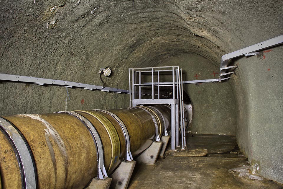 Za skromnou přechodovou lávkou se potrubí vrací do třímetrové betonové štoly, kterou pokračuje další tři kilometry. Za skromnou přechodovou lávkou se potrubí vrací do třímetrové betonové štoly, kterou pokračuje další tři kilometry.