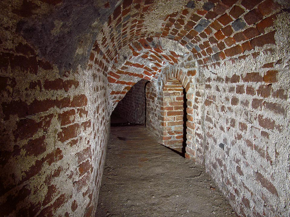 Zde již vstupujeme (obloukem vpravo) do skutečné vodovodní a kanalizační štoly. Užší a nižší. Zde již vstupujeme (obloukem vpravo) do skutečné vodovodní a kanalizační štoly. Užší a nižší.
