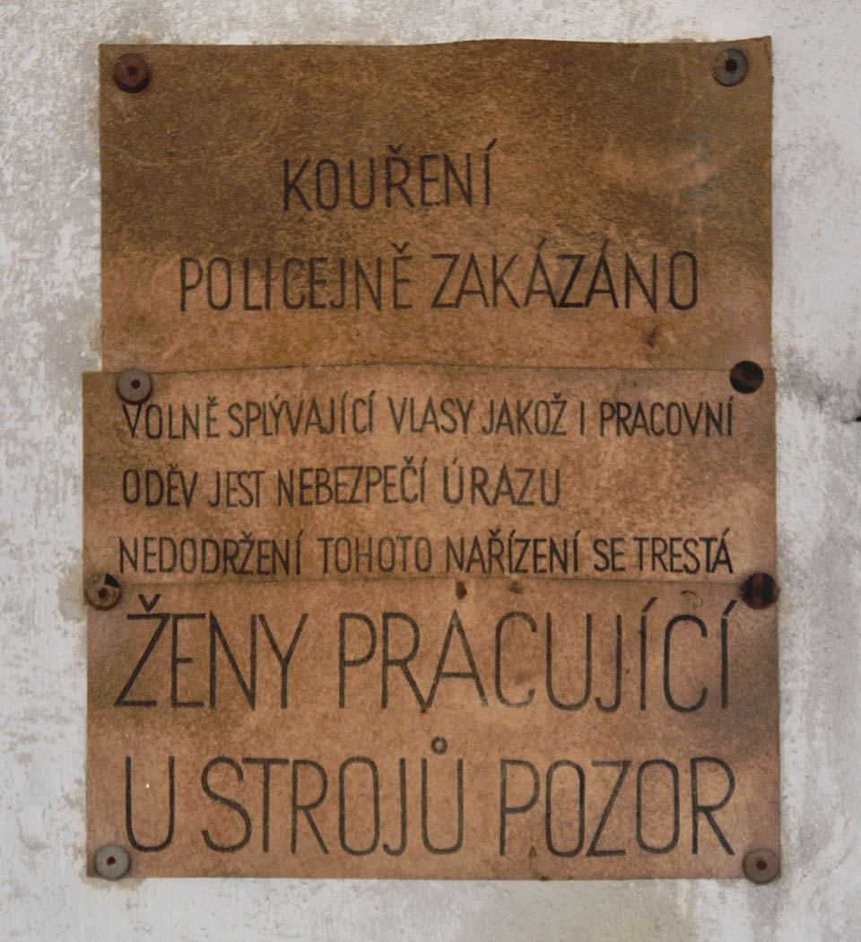Kouření policejně zakázáno.
Volně splývající vlasy jakož i pracovní oděv jest nebezpečí úrazu, nedodržení tohoto nařízení se trestá.
Ženy pracující u strojů pozor! Kouření policejně zakázáno.
Volně splývající vlasy jakož i pracovní oděv jest nebezpečí úrazu, nedodržení tohoto nařízení se trestá.
Ženy pracující u strojů pozor!